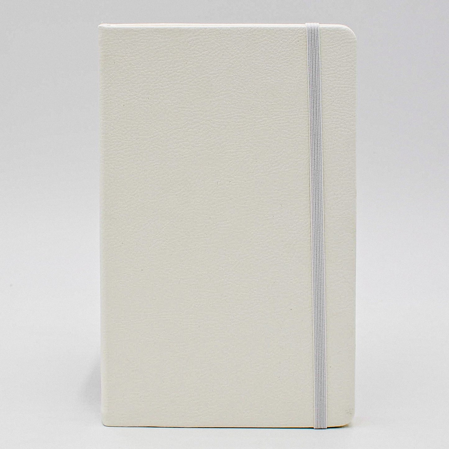 Journal: Faux Leather Lined Case Bound Book with Elastic Closure This vegan leather ruled journal is perfect for your travels, home, car, or office. With a convenient elastic band closure, keep your book closed with ease. With ivory ruled pages, keep easy notes throughout your day. Available in Tan, White, and Blue Dimensions: 5" x 8" white creme cream 5 x 8 5x8